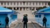 FILE - A North Korean soldier, center top, looks at South Korean soldiers at Panmunjom, March 12, 2014. Two fishermen, suspected in 16 deaths, were departed to North Korea Thursday via the border village.