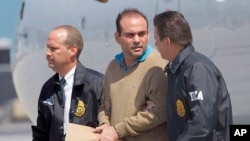 ARCHIVO - El exjefe paramilitar colombiano Salvatore Mancuso es escoltado por agentes de la DEA de Estados Unidos a su llegada a Opa-locka, Florida, el 13 de mayo de 2008. 