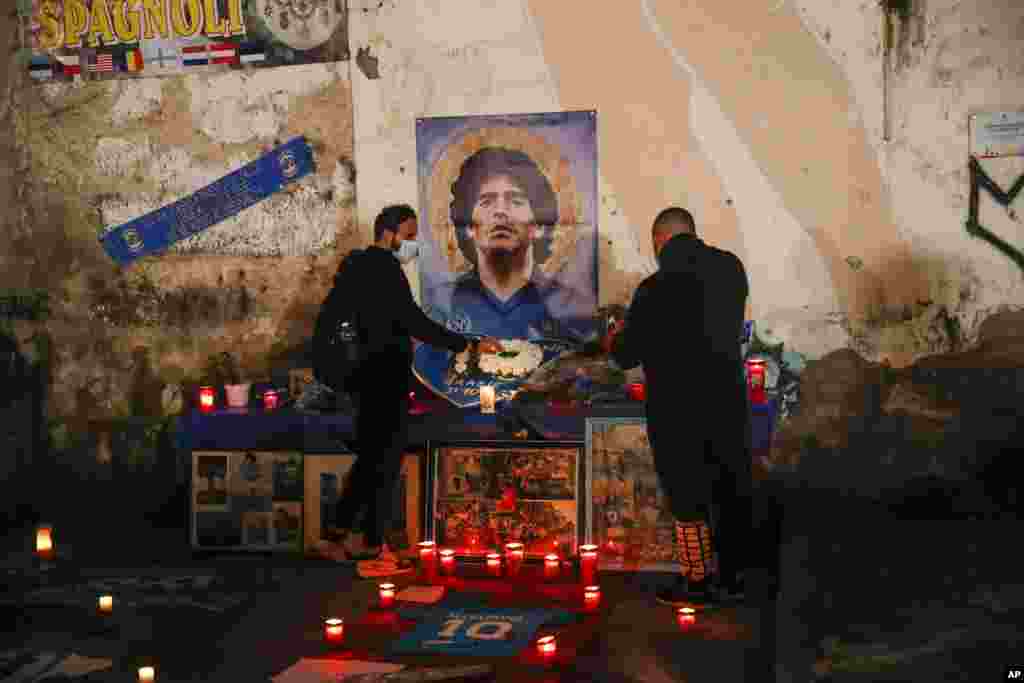People gather and light candles to honor soccer legend Diego Maradona, at the popular "Quartieri Spagnoli" neighborhood, in Naples, Italy.