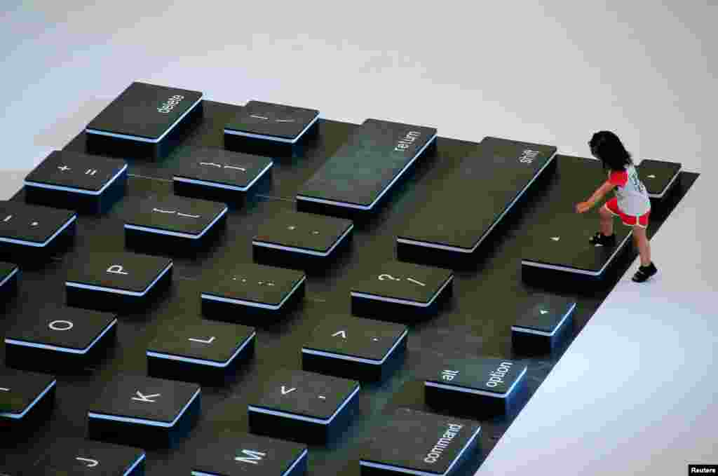 Seorang anak memanjat di sebuah "keyboard laptop" raksasa saat acara promosi di sebuah pusat perbelanjaan di Beijing, China.
