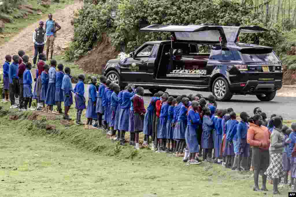 Students line up next to the road to see the hearse carrying the coffin of late marathon runner Kelvin Kiptum during his funeral proceedings in the village of Chepkorio. Kenya's world-record holding marathon runner, a prodigy who ran three of the seven fastest marathons in history and was ranked first among the world's men's marathon runners, tragically died in a car crash in Kenya on Feb. 11, 2024, at the age of 24.