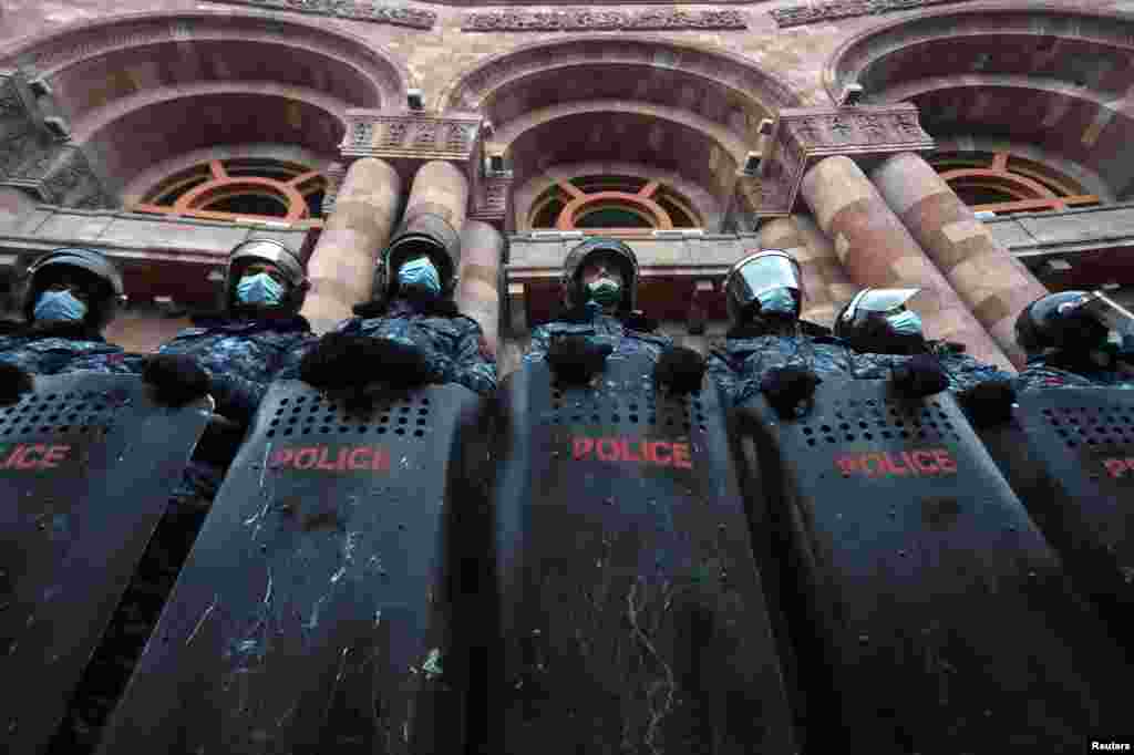 Armenian law enforcement officers stand guard outside the government office during an opposition rally to demand the resignation of Prime Minister Nikol Pashinyan following the signing of a deal to end a military conflict over Nagorno-Karabakh in Yerevan.