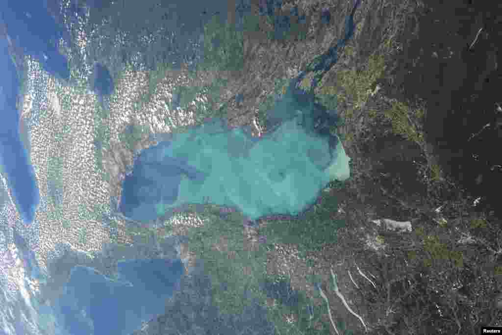 Late summer plankton blooms across much of Lake Ontario, one of North America's Great Lakes, in this photograph taken by an astronaut on the International Space Station. Microscopic cyanobacteria, or blue-green algae, can reach such large concentrations and color the water to such an extent that the change is visible from orbit. (Courtesy of NASA)