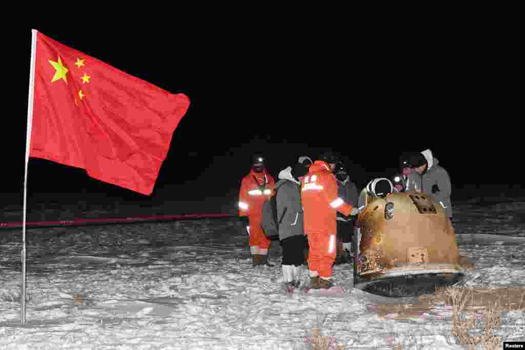 Researchers work around Chang'e-5 lunar return capsule carrying moon samples after it landed in northern China's Inner Mongolia Autonomous Region. (Credit: China Daily)