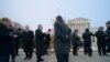 La gente fuera de la Corte Suprema antes de que los jueces escuchen argumentos en un caso presentado por los propietarios de armas en la ciudad de Nueva York, en Capitol Hill, Washington, el lunes 2 de diciembre de 2019.