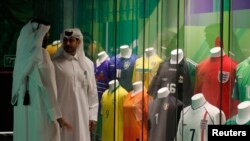 Makumbusho ya Olimpiki na Michezo ya Qatar, Doha, Qatar - Oktoba 10, 2022 Watu wamesimama karibu na jezi za kandanda zinazoonyeshwa.(REUTERS).