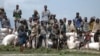 A crowd of stranded villagers gather on the banks of Ethiopia's Lake Tana (the source of the Blue Nile), as sacks of emergency food supplies are unloaded. Weeks of heavy rain have left more than 630 dead and 200,000 homeless and facing the spread of water