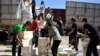 Para petugas Program Pangan Dunia PBB (WFP) dan Bulan Sabit Merah Arab Suriah mendistribusikan bantuan pangan bagi warga di kota Al-Houla yang dikuasai pemberontak, di pinggiran utara provinsi Homs, Suriah (foto: dok). 