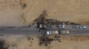 Vehicles are seen near a destroyed truck at the spot where Abu Hassan al-Muhajir, the Islamic State group's spokesman, was reportedly killed in a raid in the northern Syrian village of Ayn al-Bayda near Jarablus, Oct. 28, 2019.
