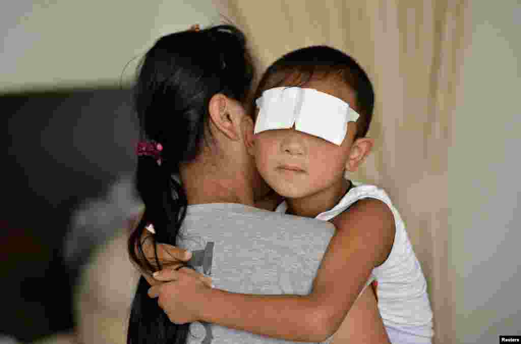 A six-year-old boy, whose eyes were gouged out, is held by his mother at a hospital in Taiyuan, Shanxi province. Chinese police suspect the boy's aunt of gouging out his eyes, Xinhua state news agency said, the latest twist in the investigation of a crime that shocked the country.