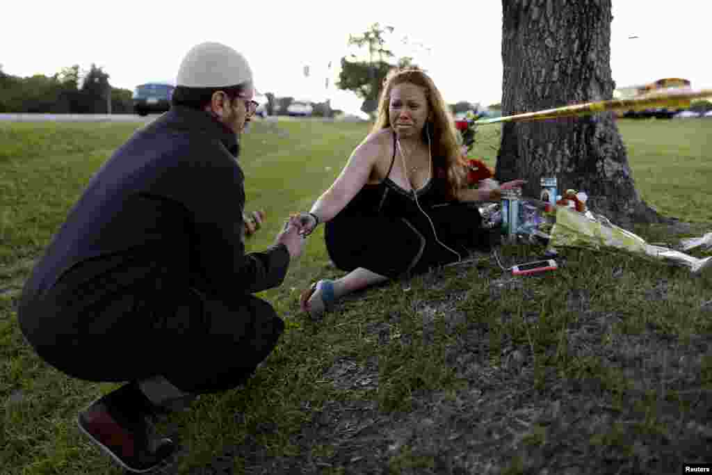 Daniel Hernandez, a local imam, comforts Dih-Anaa Forero of Missouri City, near the site of the shooting at the Santa Fe High School, in Santa Fe, Texas, May 19, 2018.