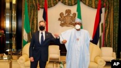Waziri wa mambo ya nje wa Marekani Antony Blinken, kushoto, akikaribishwa na Rais wa Nigeria Muhammadu Buhari, kulia, kabla ya mkutano wao katika ikulu ya Rais Abuja, Nigeria, Nov. 18, 2021. 