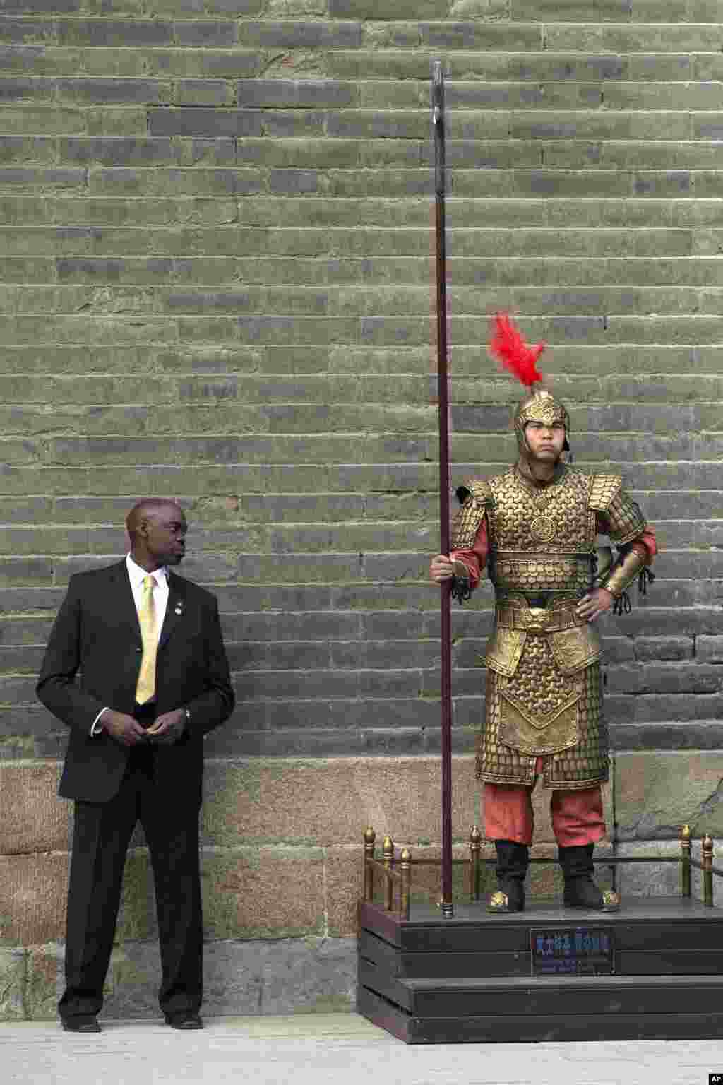 A U.S. secret service officer checks a Chinese performer dressed as an ancient warrior as U.S. first lady Michelle Obama visits a nearby city wall in Xi'an, in northwestern China's Shaanxi province.