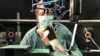 A researcher observes a rat walking on its hind legs during an experiment involving spinal cord injuries, at the Center for Neuroprosthetics and Brain Mind Institute in Ecublens, Switzerland, May 31, 2012.