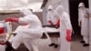 FILE - health workers wearing Ebola protective gear remove the body of a man they suspect died from the Ebola virus, at a USAID, American aid Ebola treatment center on the outskirts of Monrovia, Liberia, Nov. 28, 2014.
