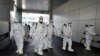 Workers from a disinfection service company sanitize a branch of the Shincheonji Church of Jesus the Temple of the Tabernacle of the Testimony, where a woman known as "Patient 31" attended a service in Daegu, South Korea, Feb. 19, 2020. 