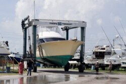 A large boat is moved to a storage lot on dry land at a marina in Cape Canaveral, Fla., as boat owners prepare for the arrival of Hurricane Dorian, Aug. 31, 2019,