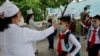 FILE - Kim Song Ju Primary School students have their temperatures checked in Pyongyang, North Korea, June 3, 2020. After months of denying it had any coronavirus infections, North Korea reported its first suspected case July 25, 2020.