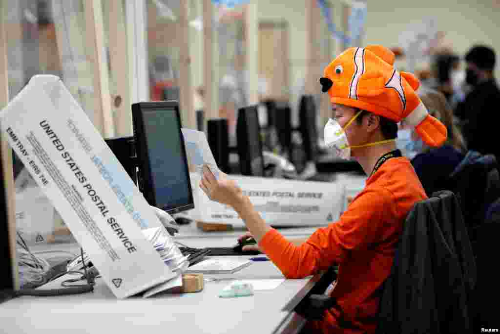 An employee wears a halloween costume while processing early voting and absentee ballots ahead of the upcoming presidential election in Tucson, Arizona, USA, Oct. 31, 2020.
