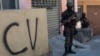 FILE - A soldier stands guard next to a wall tagged with the acronym "CV" identifying the criminal organization "Comando Vermelho" or Red Command, during an operation at the Rocinha slum, in Rio de Janeiro, Brazil, Oct. 10, 2017. 