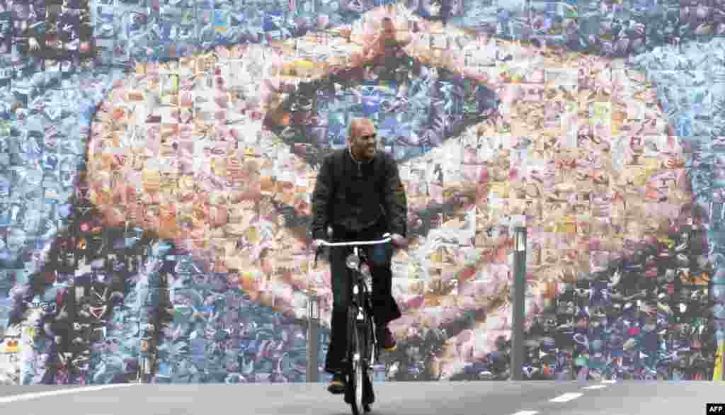A cyclist rides past a giant election billboard featuring German Chancellor Angela Merkel's hands in a trademark pose in Berlin ahead of general elections on Sept. 22.