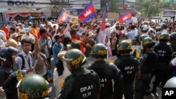 Polisi anti huru-hara Kamboja menghadang para demonstran yang dipimpin oleh pemilik stasiun radio Radio Beehive, Mam Sonando, saat berunjuk rasa menuntut ijin bagi sebuah stasiun televisi independen di Phnom Penh, Kamboja (27/1).