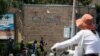 A security guard stands on duty as residents pass by the Canadian Embassy in Beijing on Friday, June 19, 2020. Chinese prosecutors charged two detained Canadians with spying Friday in an apparent bid to step up pressure on Canada to drop a U.S…
