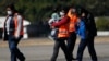 Un funcionario de inmigración guatemalteco lleva a un menor que fue deportado de Estados Unidos. 