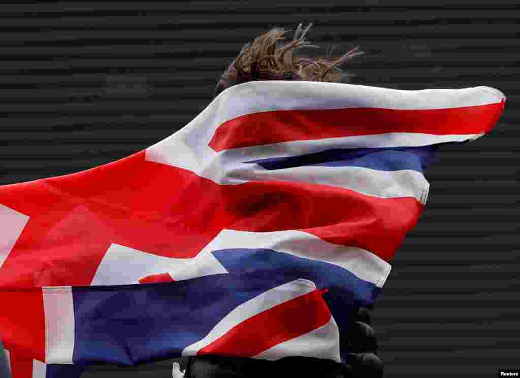 Union Jack flag is blown into the face of a fan before the match between Celtic and Rangers during Scottish Cup semi final in Glasgow, Britain.