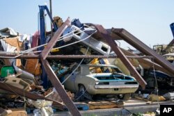Se ven vehículos en un taller de carrocería entre escombros la mañana después de que pasara un tornado, el domingo 26 de mayo de 2024, en Valley View, Texas, EEUU.