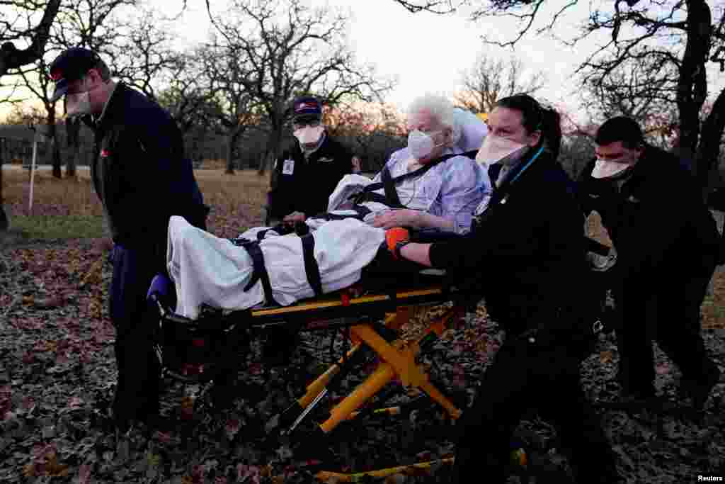 REACT EMS paramedics prepare to transport an 87-year-old woman who had been exposed to the coronavirus disease (COVID-19) and was experiencing symptoms in Meeker, Oklahoma, Dec. 20, 2020.