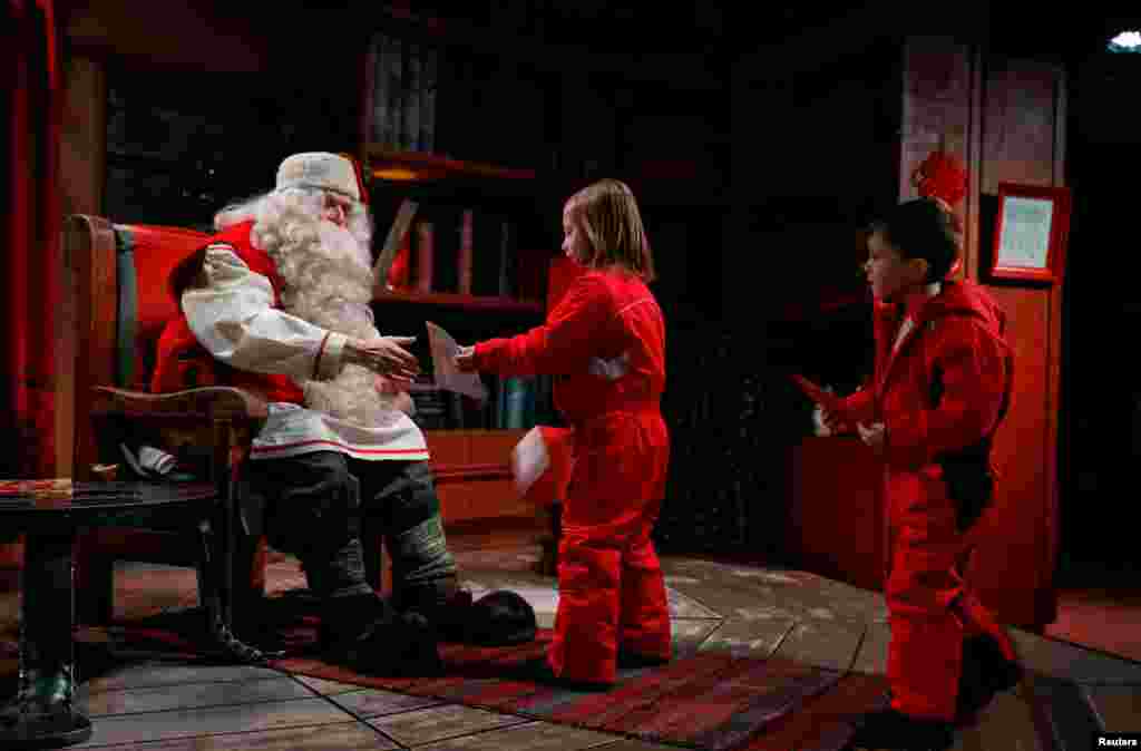 Everyday, Santa is busy meeting children around the world coming to see him. In this picture, he talks to Eloise and Noah Seymour from England at Santa Claus' Village.