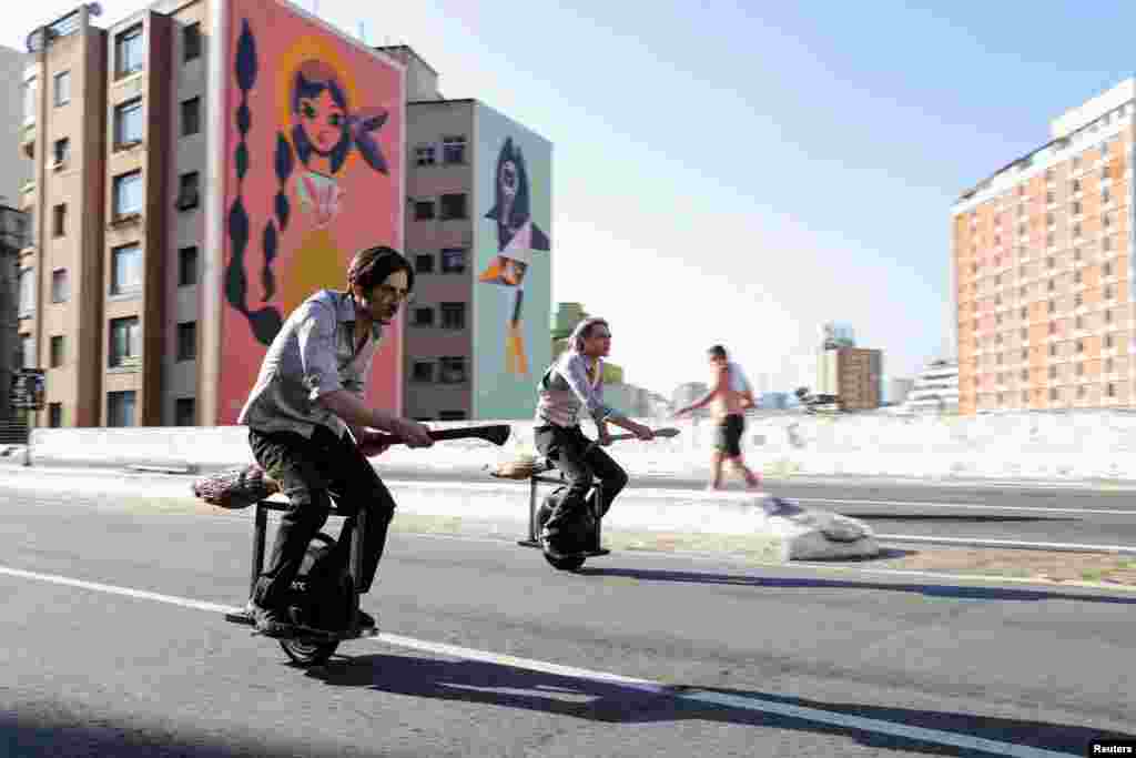 Vinicius Sanctus and Alessandro Russo ride electric monowheels called 'nuvem' (cloud) in Sao Paulo, Brazil. Their invention was inspired by the magic flying brooms of the Harry Potter series.