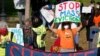 FILE - Protesters display placards while calling for support for tenants and homeowners at risk of eviction during a demonstration on the Boston Common, in Boston, Oct. 11, 2020.
