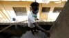FILE - A visually impaired man climbs the stairs at a building where he lives, in Lagos, Nigeria, May 5, 2020. 