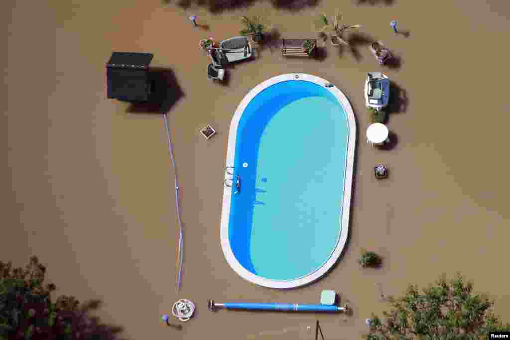 A garden with a swimming pool is inundated by the waters of the Elbe river during floods near Magdeburg in the federal state of Saxony Anhalt, Germany, June 10, 2013. Tens of thousands of Germans, Hungarians and Czechs were evacuated from their homes as soldiers raced to pile up sandbags to hold back rising waters in the region's worst floods in a decade.