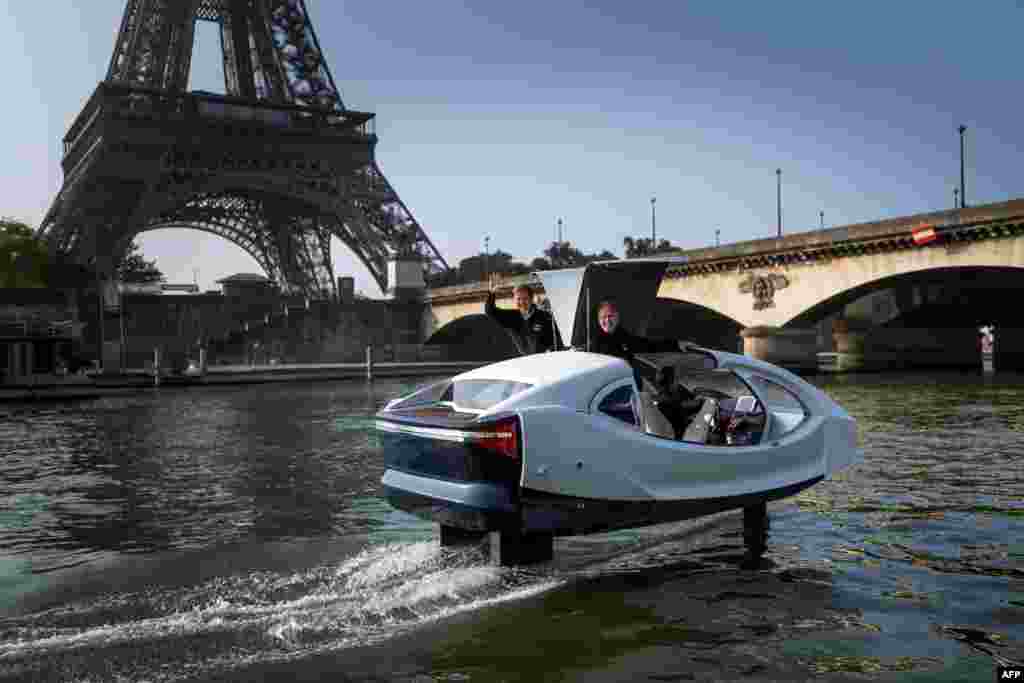 Sea Bubbles start-up founders Alain Thebault (L) and Anders Bringdal (R) stand on board a Sea Bubble electric maritime "flying taxi" during a demonstration on the river Seine in Paris, France.