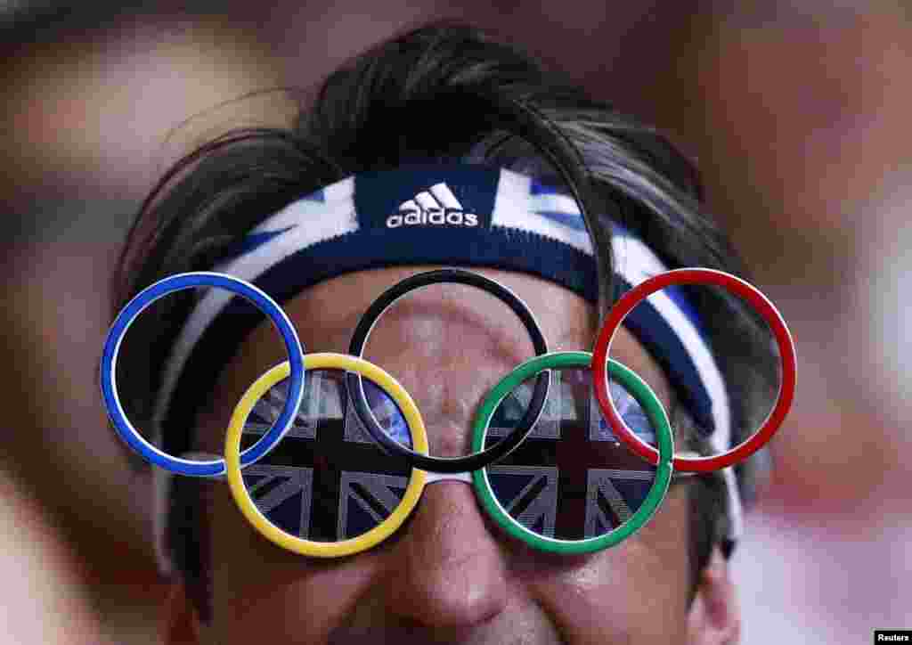 Spectator wears glasses with the shape of the Olympic logo attending the men's 94Kg group B weightlifting competition at the ExCel venue at the London 2012 Olympic Games August 4, 2012.