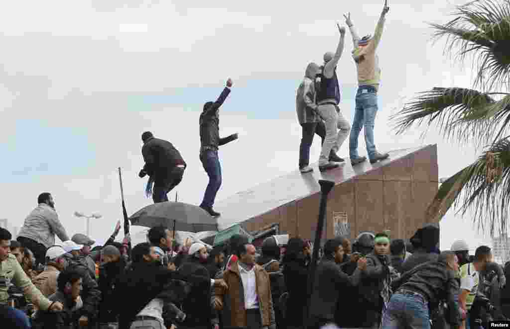 Protesters supporting Egyptian President Mohamed Morsi gesture as anti-Morsi protesters throw rocks at them during clashes in Alexandria, Egypt, December 21, 2012.