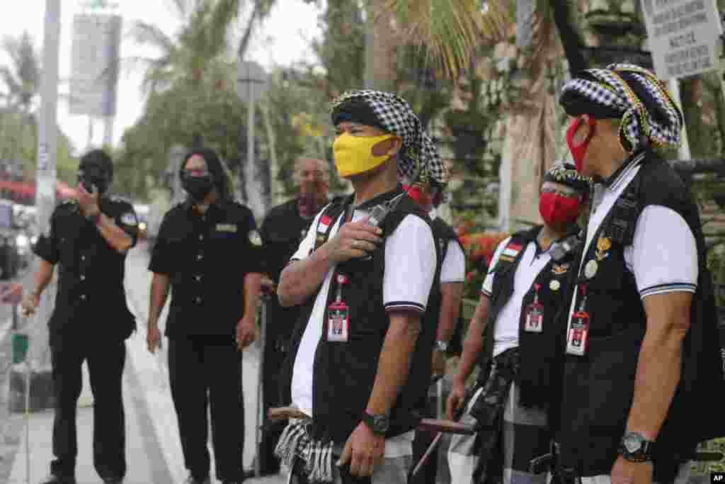 Traditional guards called 'pecalang' guard the access to Kuta Beach, a famous spot normally crowded with tourists on New Year's eve, on the resort island of Bali, Indonesia. The government banned New Year's celebration events that could attract crowds to prevent the spread of coronavirus outbreak. 